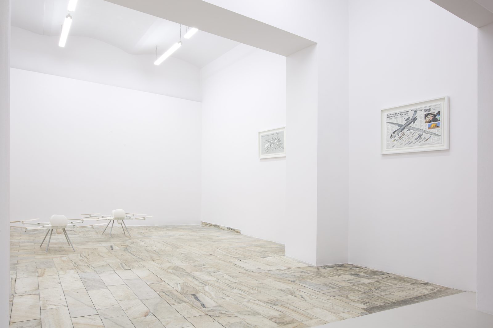 Asymmetric Futures, installation view of the lower room with the SWARM drones on the floor and two framed Exploded Views drawings